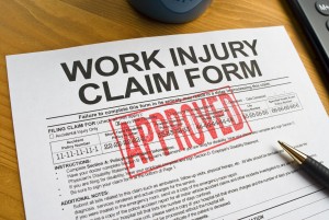 Approved work injury claim form with a pen on a desk, representing successful workers’ compensation claims