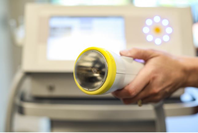 Close-up of a SoftWave Therapy machine handpiece used for regenerative shockwave treatment in a clinical setting